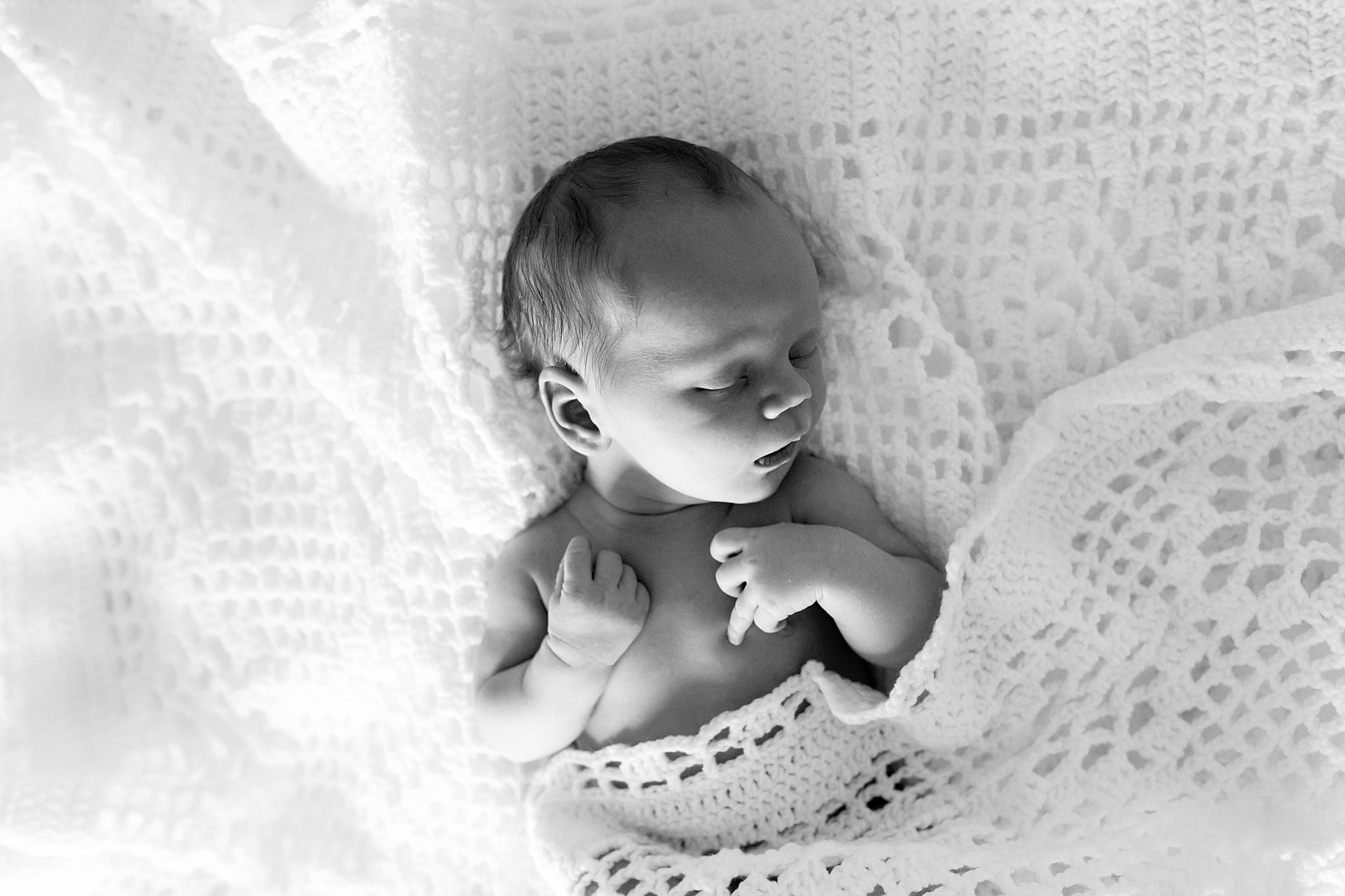 Newborn baby sleeping in its crib during a session of newborn photography in New York. 