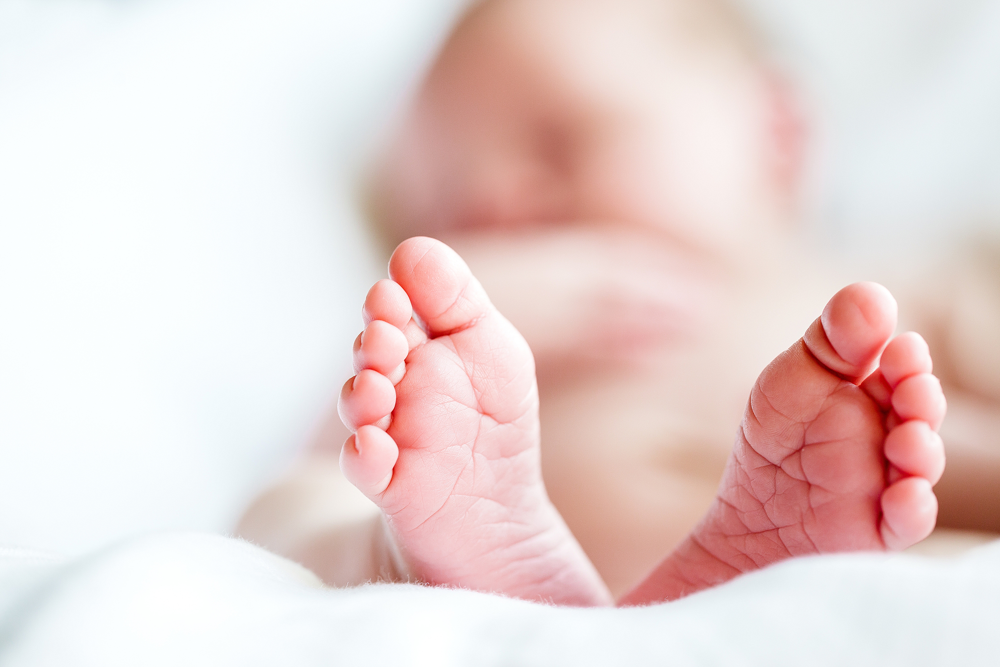 Photo of newborn baby sleeping, with feet in focus.
