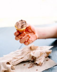 Child holding a melting chocolate ice cream cone at King Kone in Katonah, New York during a summer family outing.