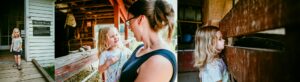 Young child and parent exploring the barns and farm animals at Muscoot Farm in Katonah, New York during a summer family outing.